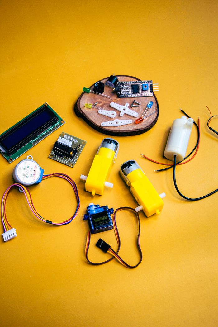 About Top view of robotic kit parts on vibrant yellow background, ideal for tech projects.
